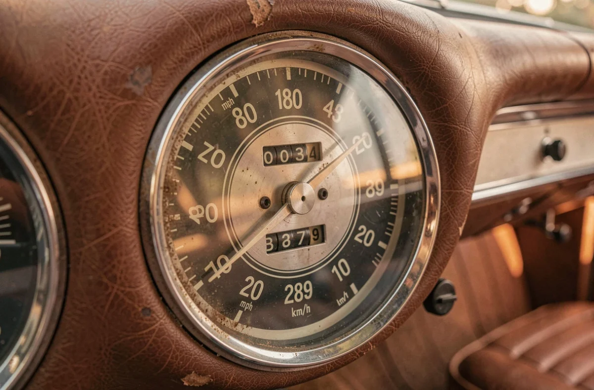 Gros plan sur un compteur de vitesse vintage affichant 180 mph et la conversion en kmh sur le cadran