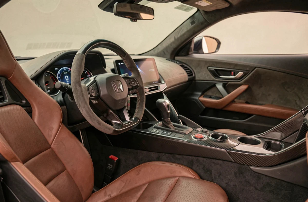 Intérieur du cockpit de la Honda NSX hybride avec tableau de bord numérique et finitions carbone