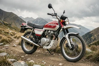 Honda XLV750R rouge et blanc garée sur une piste de montagne rocailleuse, vue grand angle mettant en valeur son moteur V-twin et ses pneus tout-terrain