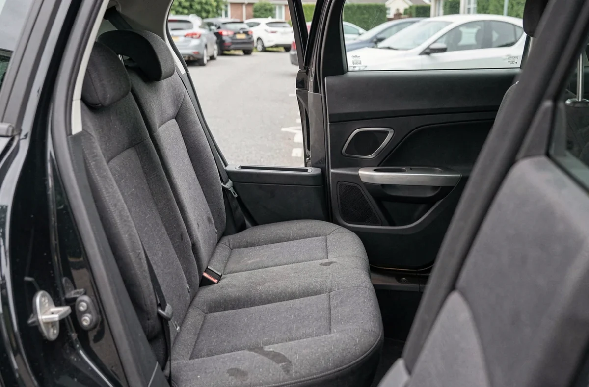 Banquette arrière de la Peugeot 308 en finition d'entrée de gamme avec habillage tissu sobre et panneau de porte minimaliste